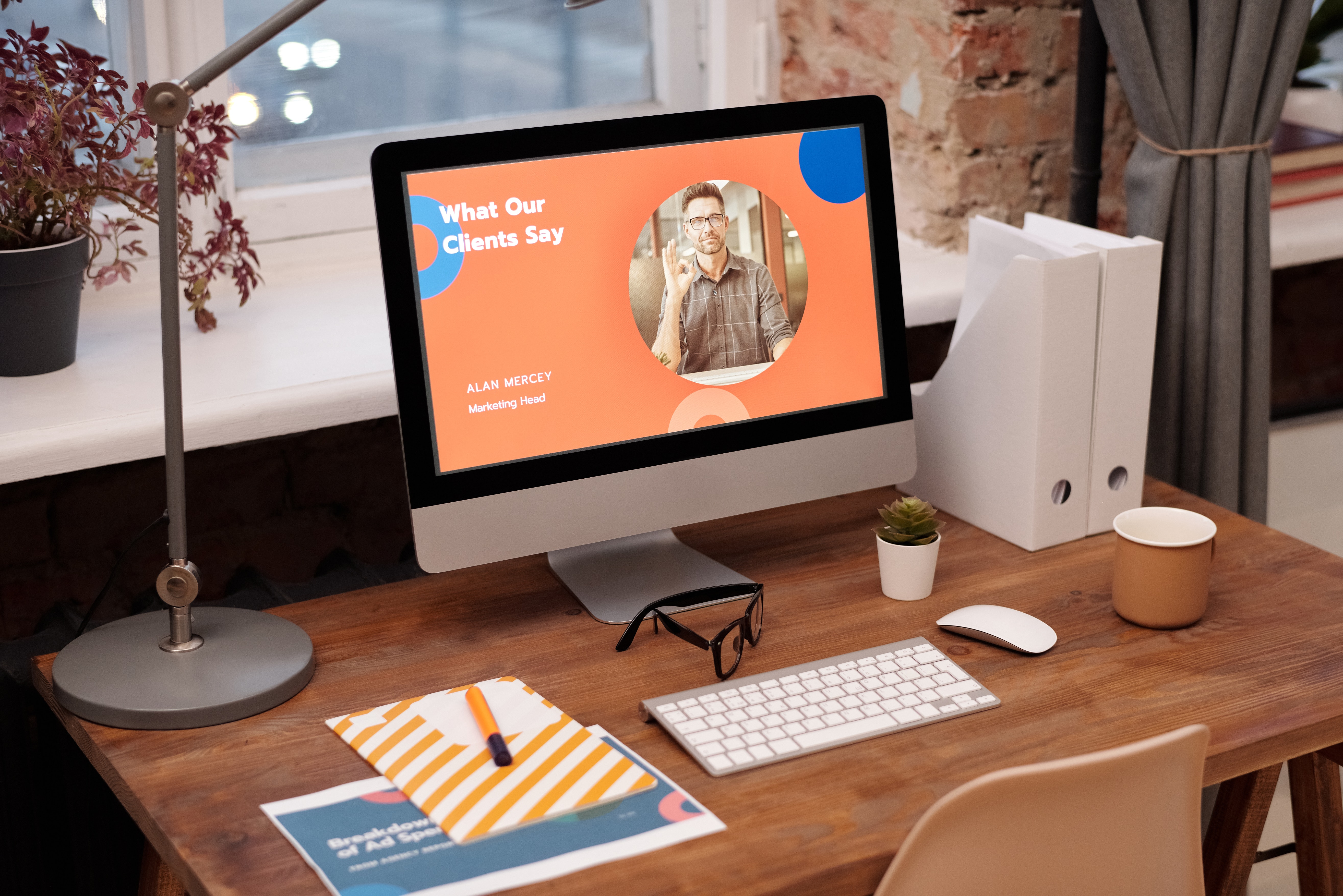 A wooden desk a keyboard and a laptop on top that displays a presentation